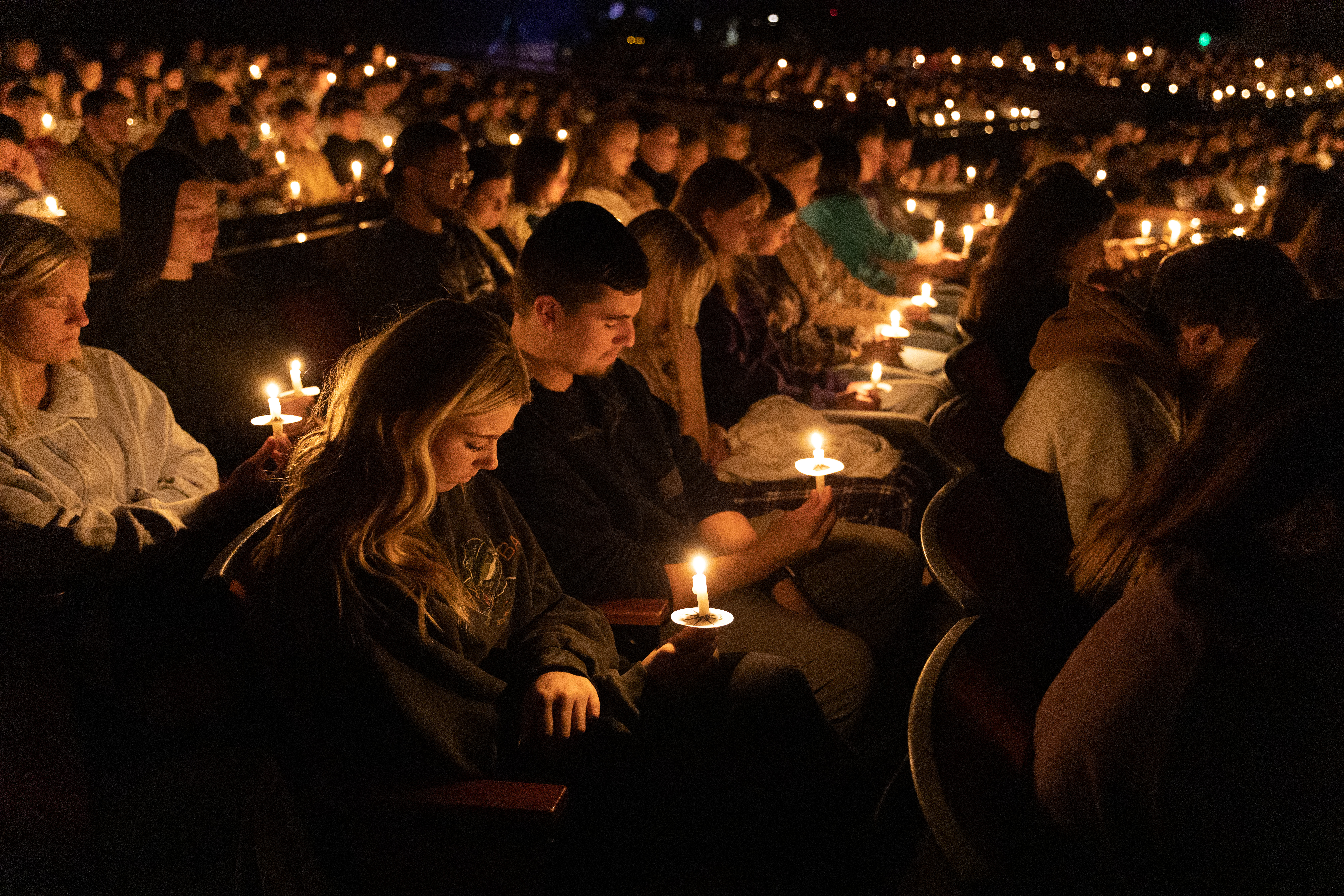 Students pray during candlelight service